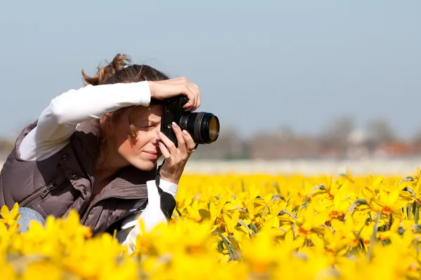 Девушка делает фотографии цветов — стоковое фото