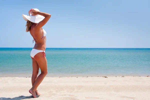 Νεαρή γυναίκα, απολαμβάνοντας τον ήλιο σε μια παραλία — Φωτογραφία Αρχείου