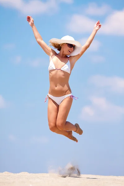 Giovane donna che salta su una spiaggia — Foto Stock
