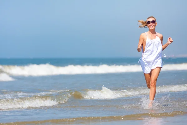 Kvinna springer på stranden — Stockfoto