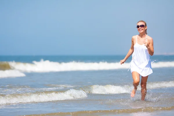 Женщина бежит по пляжу — стоковое фото