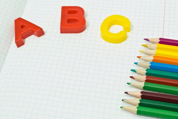 Color pencils and plastic letters abc — Stock Photo, Image