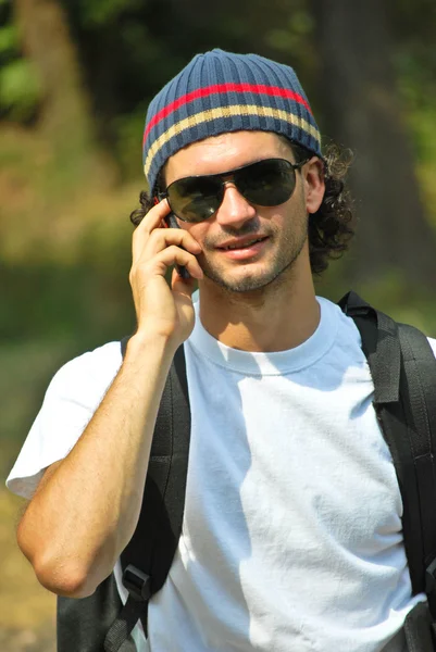 Człowiek uśmiechający się i rozmawia przez telefon komórkowy — Zdjęcie stockowe