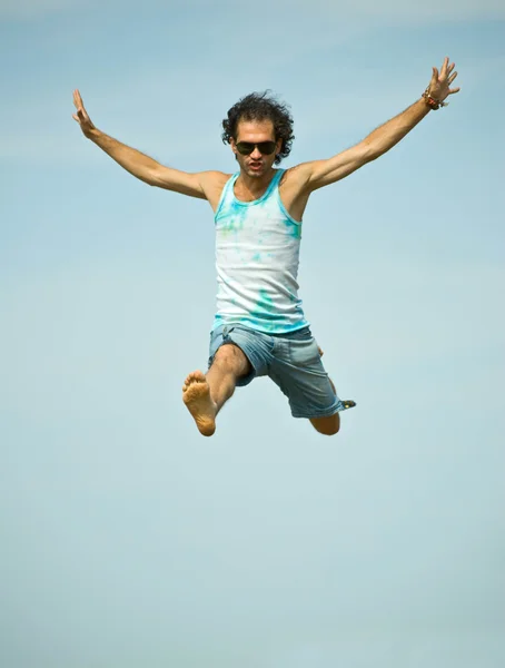 Man hoppar på himmel bakgrund — Stockfoto