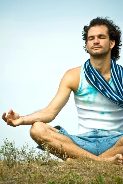 Young man sitting in lotus position — Stock Photo, Image