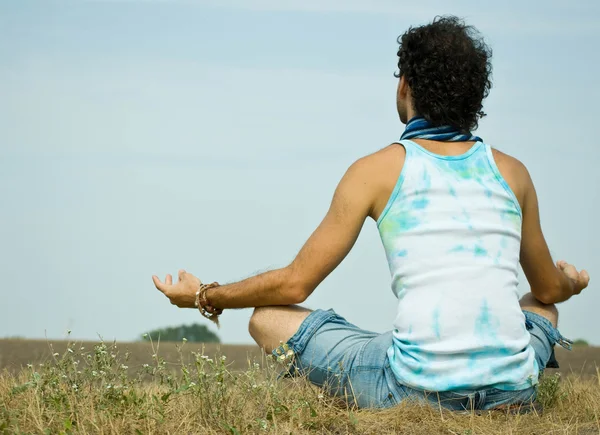 Young man sitting in lotus position — Stock Photo, Image