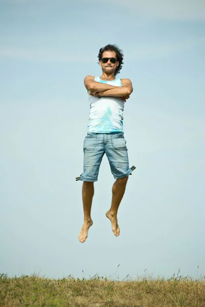 Hombre saltando en el cielo fondo Imagen de archivo