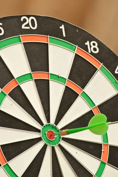 Dartboard met groene dart — Stockfoto