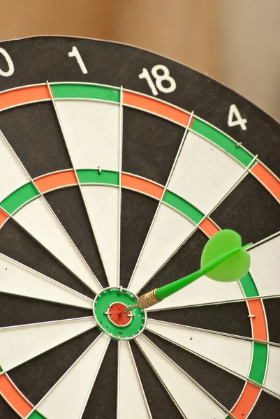Dart board with green dart — Stock Photo, Image