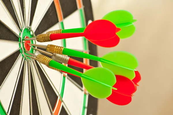 Dartboard met rode en groene darts — Stockfoto