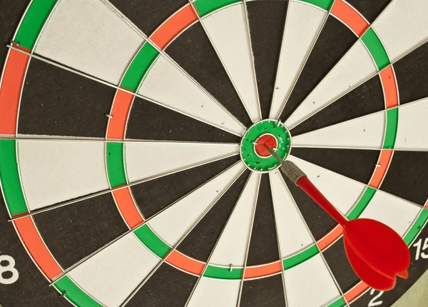 Dart board with red dart — Stock Photo, Image