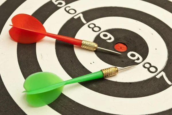 Dart board with green and red darts — Stock Photo, Image