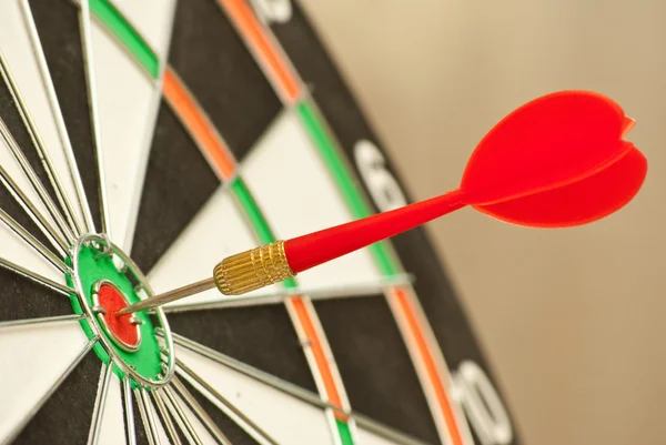 Dart board with red dart Royalty Free Stock Photos