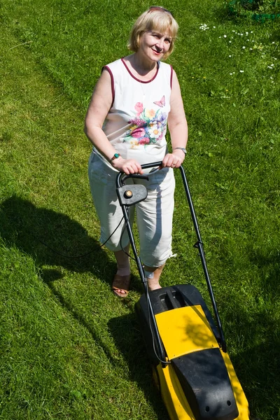 A woman with an electric mower at the cottage — Stock Photo, Image