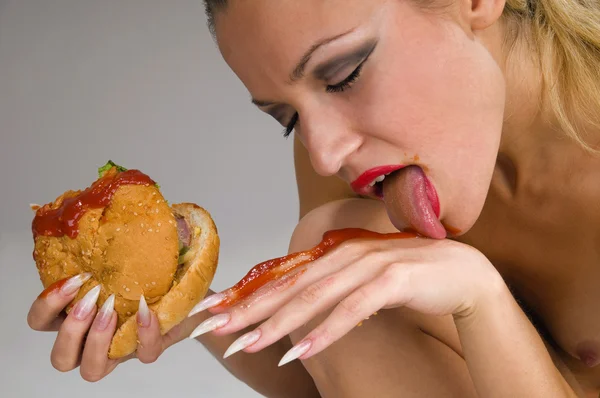 Meztelen nő eszik egy hamburgert — Stock Fotó