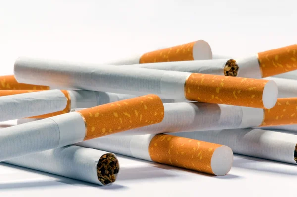 Cigarrillos acostados sobre un fondo blanco — Foto de Stock