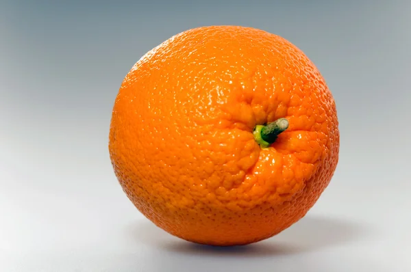 Šťavnatý pomeranč je na šedém pozadí — Stock fotografie