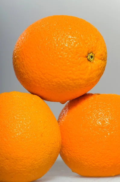Tre apelsiner liggande på marken — Stockfoto