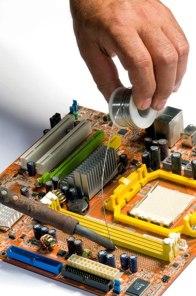Handen werken met een soldeerbout over de chip — Stockfoto