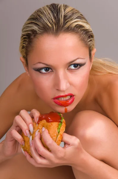 Красива гола жінка їсть гамбургер — стокове фото