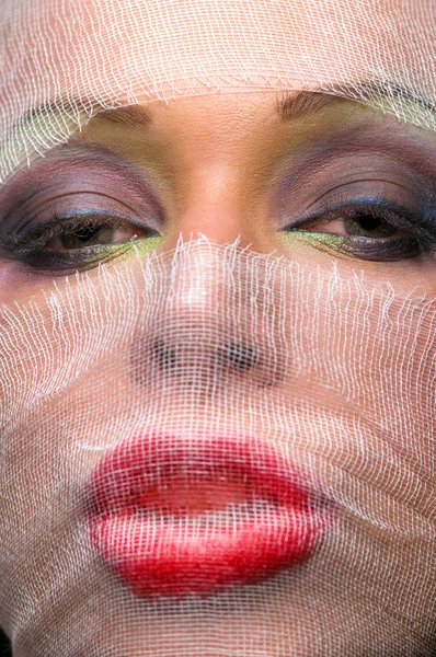 Лицо женщины с ярким макияжем, покрытым марлей — стоковое фото