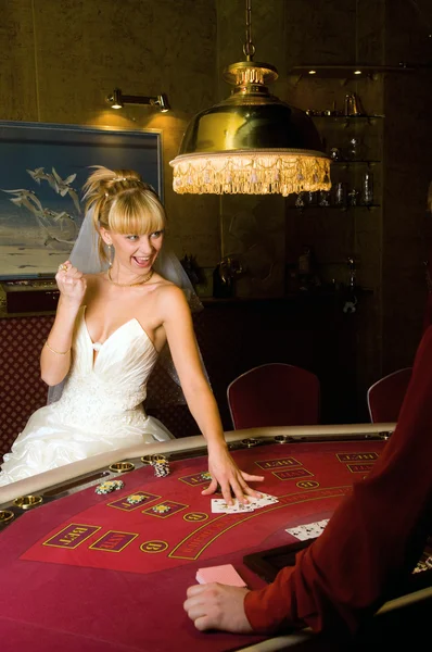 Happy bride playing cards in a casino — Stock Photo, Image