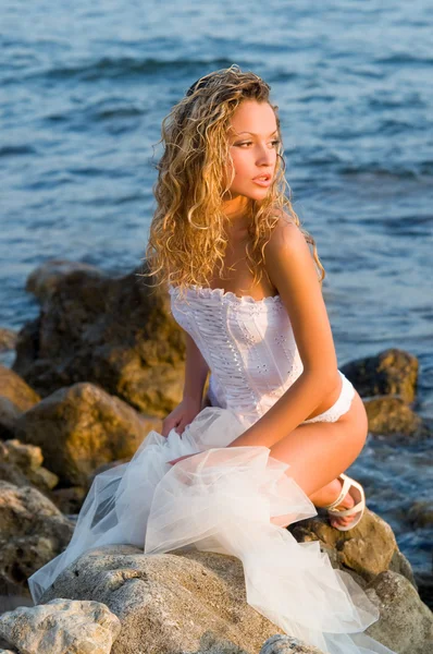 Young bride sitting on a rock — Stock Photo, Image