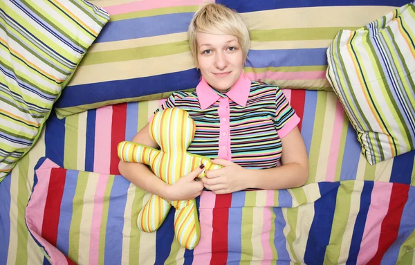 Mujer feliz en una cama acariciada —  Fotos de Stock