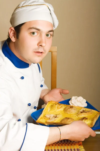 Pohledný mladý kuchař v obývacím pokoji w — Stock fotografie
