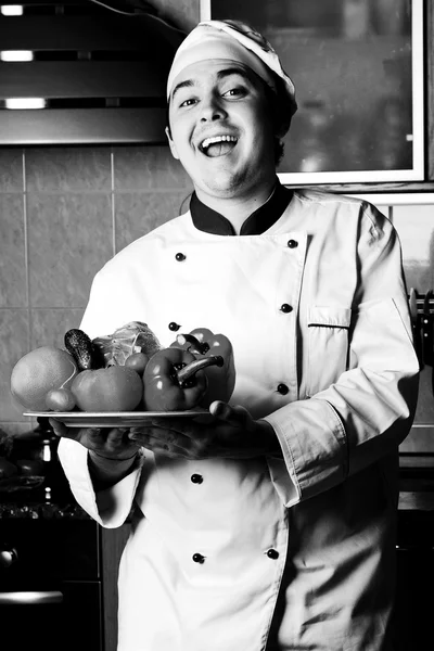 Счастливый человек с овощами на кухне — стоковое фото