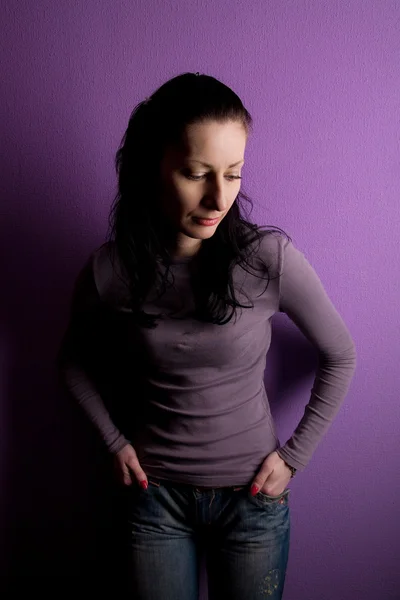 Einsame Frau trauert auf lila Hintergrund — Stockfoto