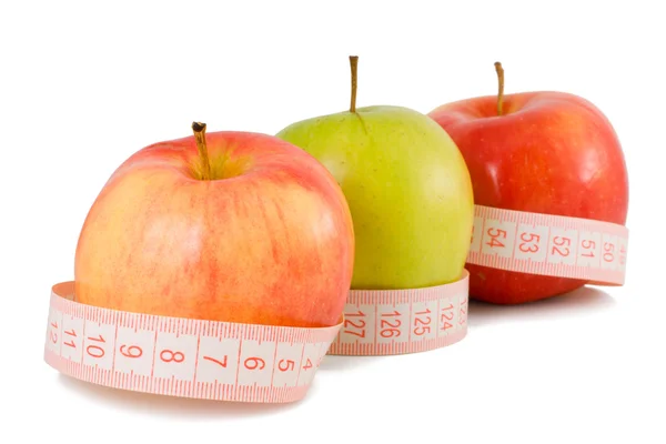 Růžová měřicí pásky a tři jablka — Stock fotografie