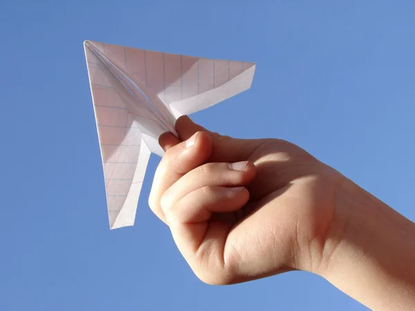 Dítě ruku s papírové letadlo — Stock fotografie