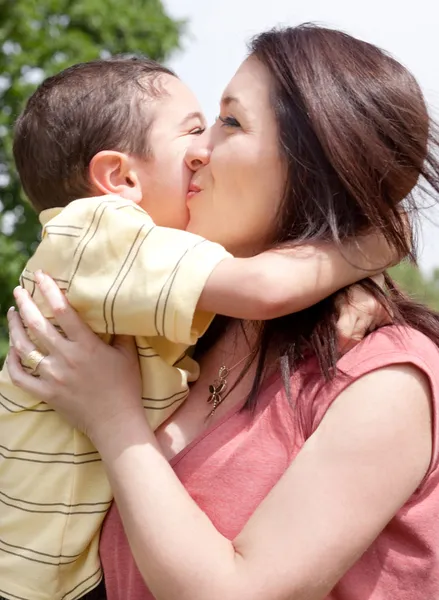 Barn kysser hans mamma i parken — Stockfoto