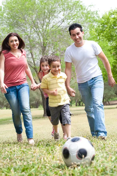 Семья играет в футбол и весело — стоковое фото