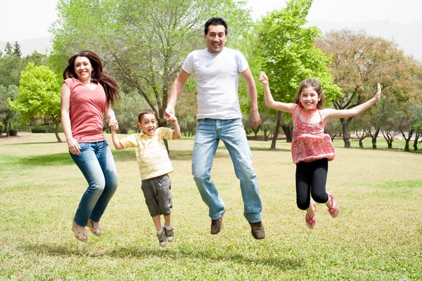 在公园里一起跳跃的家庭 — 图库照片