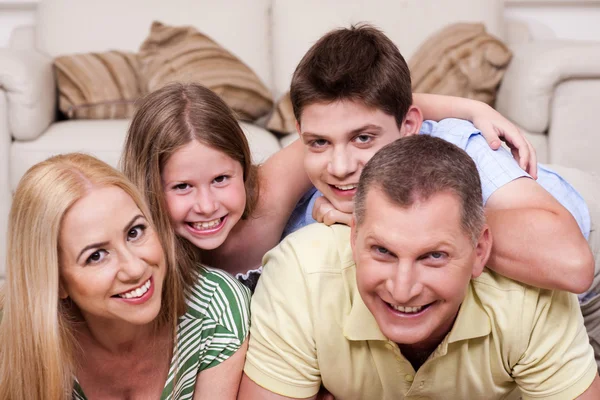 Glimlachend familie samen op de vloer liggen — Stockfoto