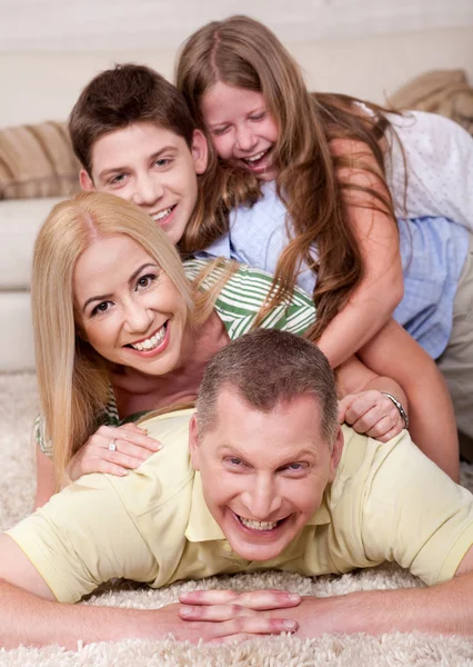 Porträt einer glücklichen Familie, die an der Spitze liegt — Stockfoto