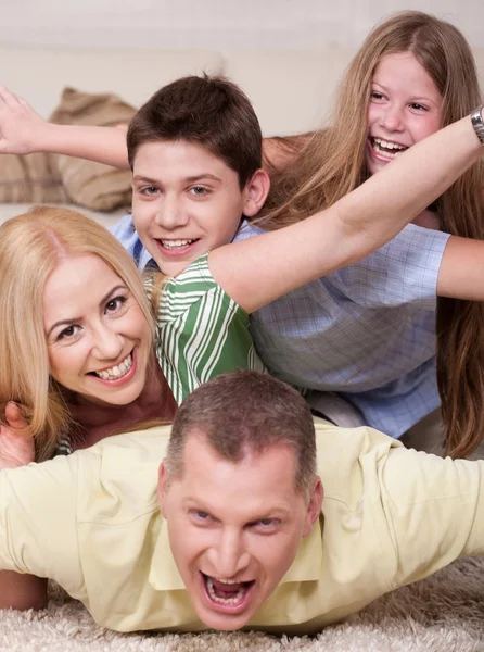 Boven op elkaar liggen en gelukkige familie — Stockfoto