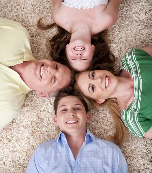Happy family lying with their heads — Stock Photo, Image