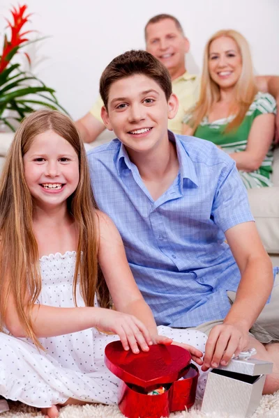 Happy young kids with gift boxes in living room — Stock Photo, Image