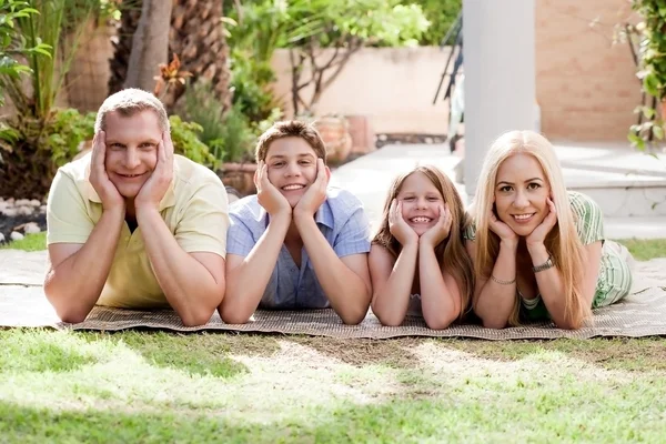 Schöne Familie auf ihrem Hinterhof und schaut dich an — Stockfoto