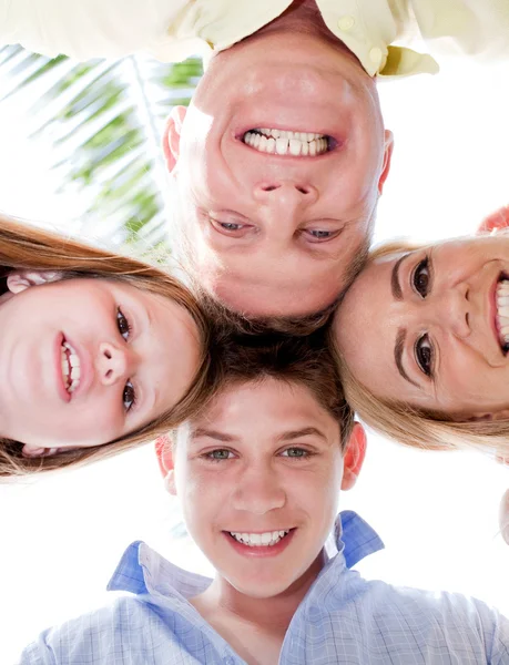 Glückliche Familie, die lächelt und die Köpfe zusammenhält — Stockfoto