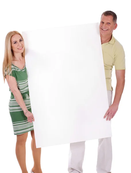 Orta yaşlı gülümseyen iki boş bir beyaz tahta holding — Stok fotoğraf