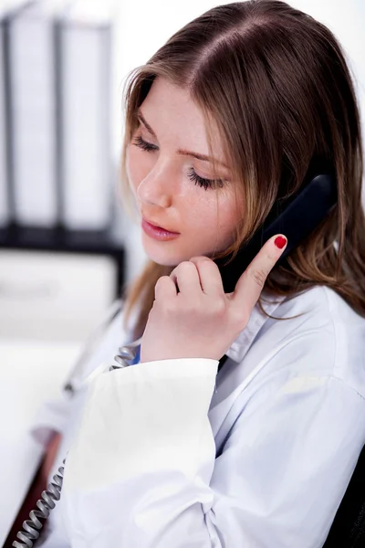 Vrouwelijke arts praten over de telefoon — Stockfoto