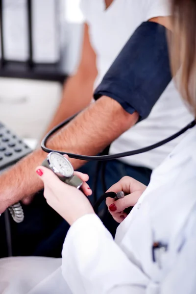 Vrouwelijke arts controleren van bloeddruk — Stockfoto