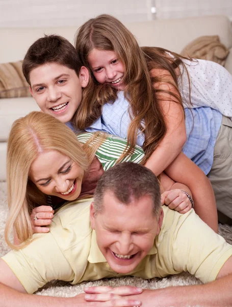 快乐的四人家庭在床上很开心 — 图库照片
