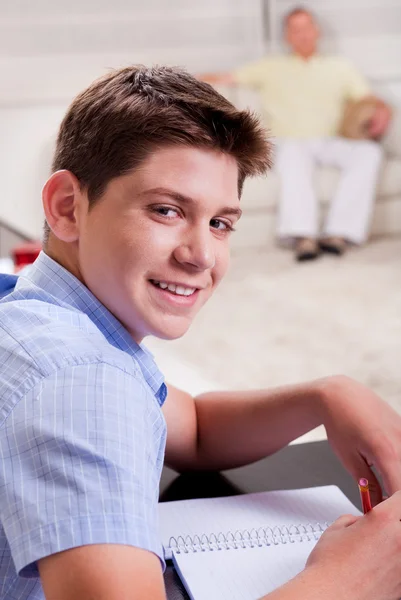 Młody chłopak w ostrości, studia i uśmiecha się do kamery — Zdjęcie stockowe