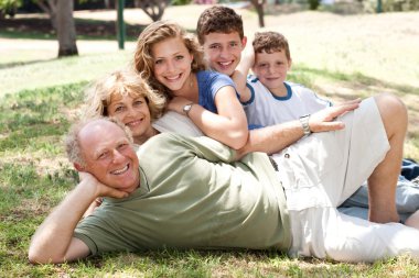 Family lying in the park clipart