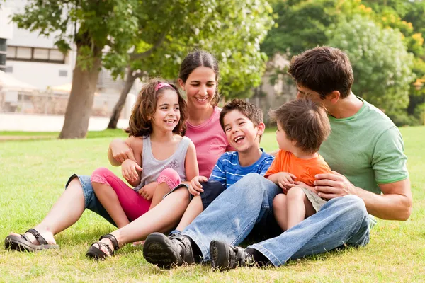 Szczęśliwa rodzina bawiąca się w parku — Zdjęcie stockowe